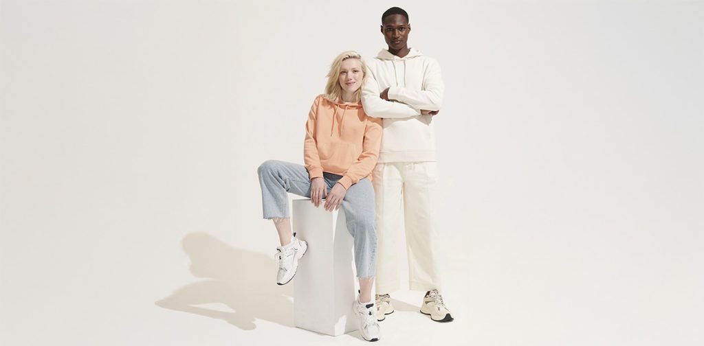 Look tendance avec un hoodie personnalisé clair, porté par un couple de mannequins